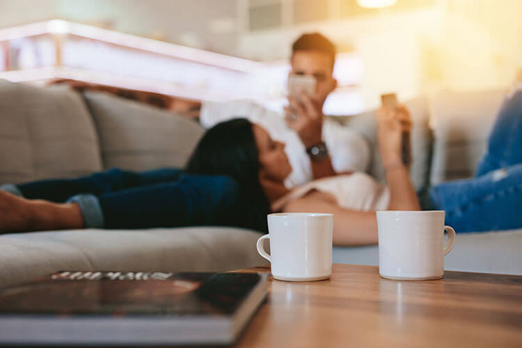 couple lying on the couch with their phones