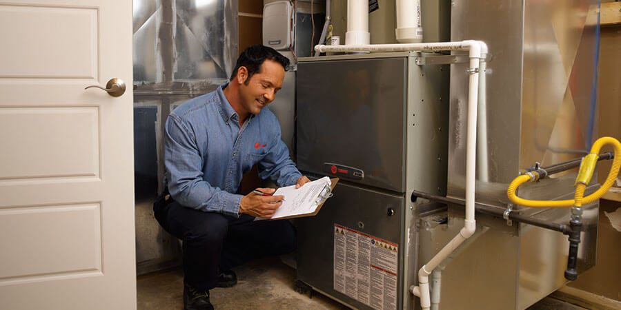 trane technician checking ac unit