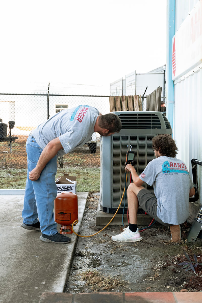 Technicians working on an ac unit